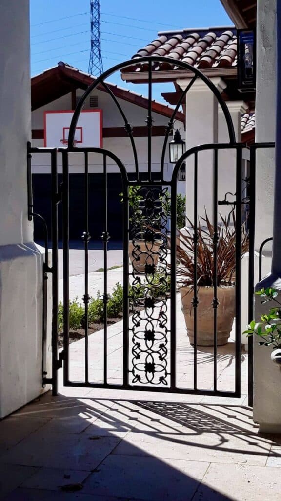 Durable aluminum pedestrian gate installed by J&M Welding Inc., providing secure and stylish access to a private back patio area with minimal maintenance required.