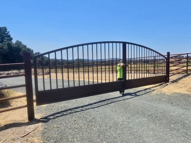 Completed custom metal gate across a gravel driveway in Paso Robles, showing full span and alignment