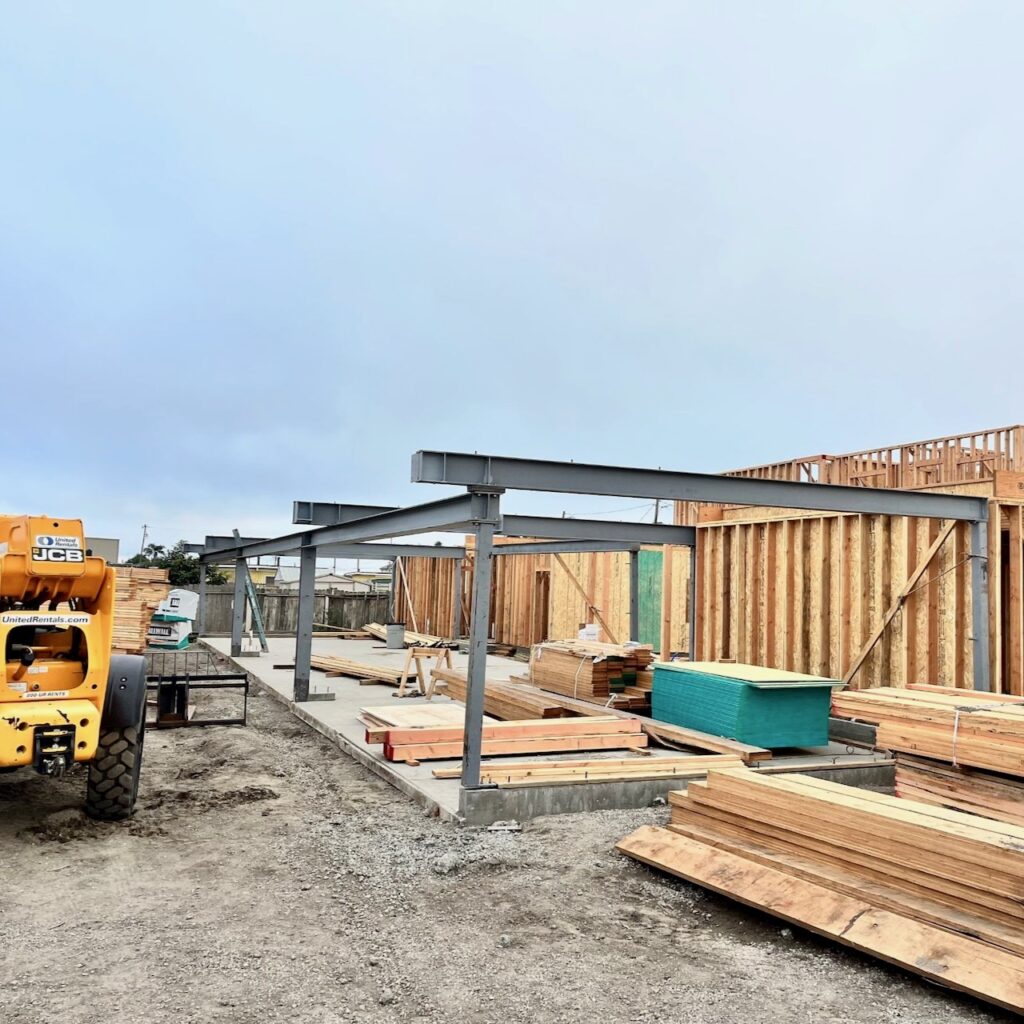 Partially completed structural steel framework installed at a construction site in Guadalupe, CA, showcasing the steel beams integrated with the wooden framing.