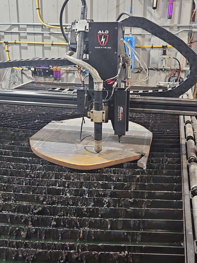 CNC plasma torch cutting steel plate for excavator bucket ear components.